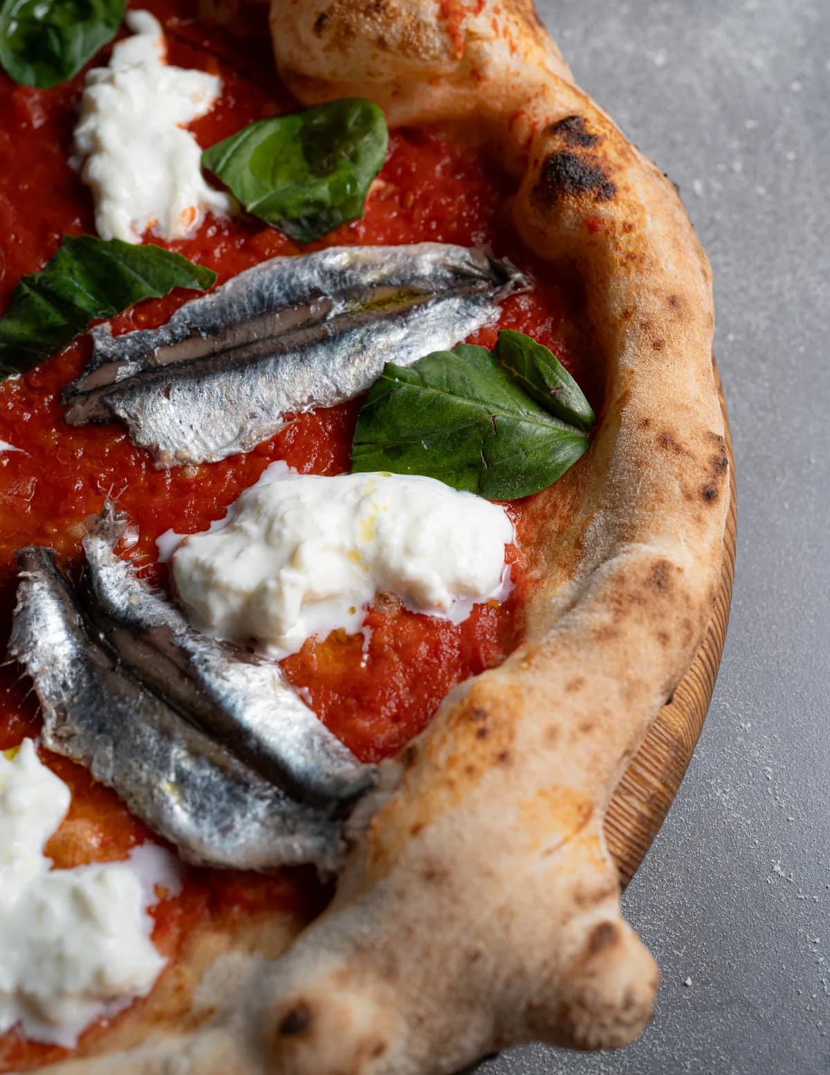 Dettaglio del cornicione dorato con alici di Cetara e mozzarella di bufala