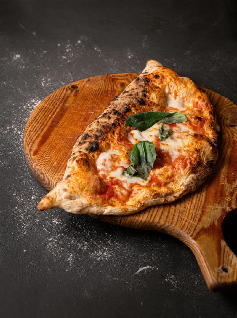 Il nostro calzone al forno: pomodoro, fior di latte filante e basilico fresco