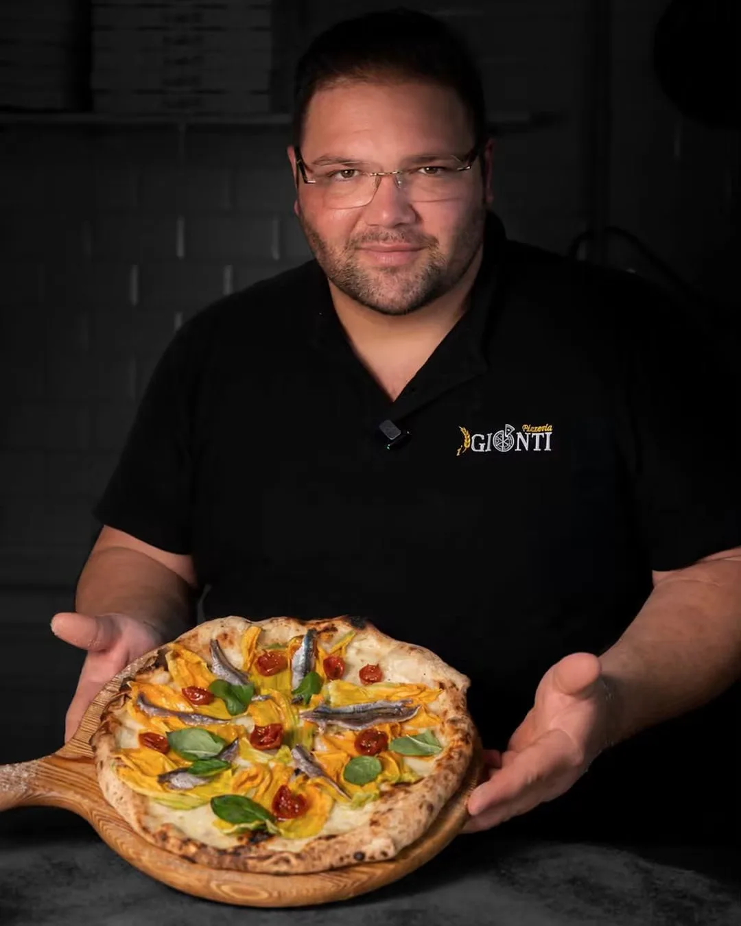 Salvatore Gionti con una pizza ai fiori di zucca e alici
